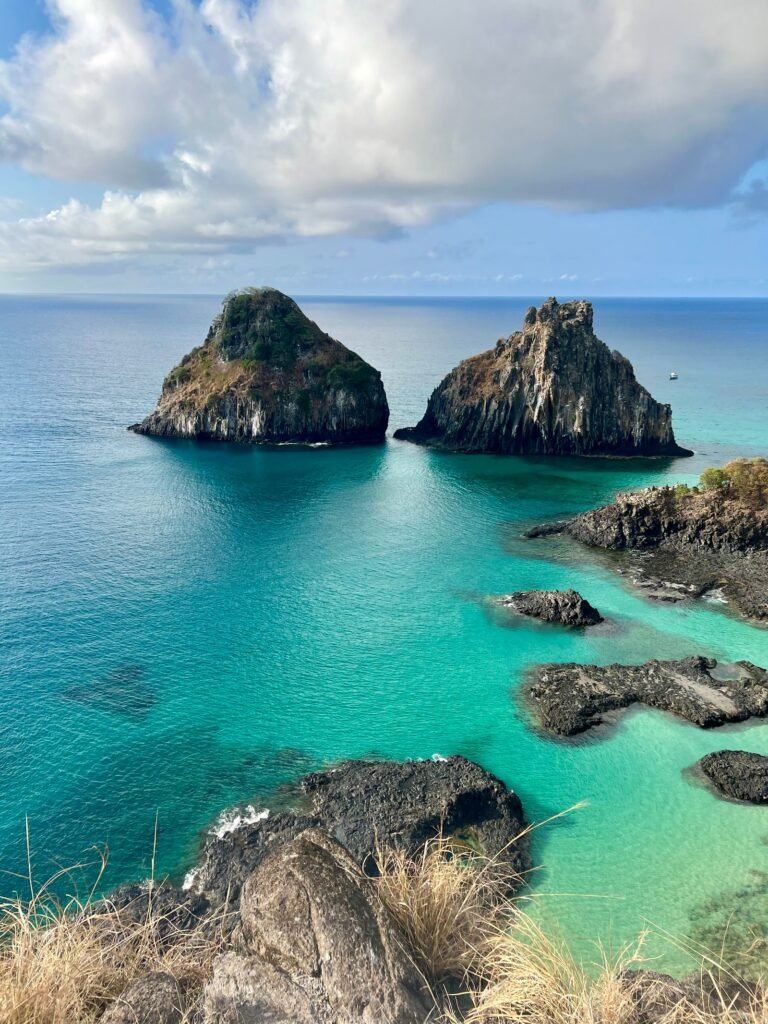 Mar esverdeado e formações rochosas na Baía dos Porcos, Fernando de Noronha