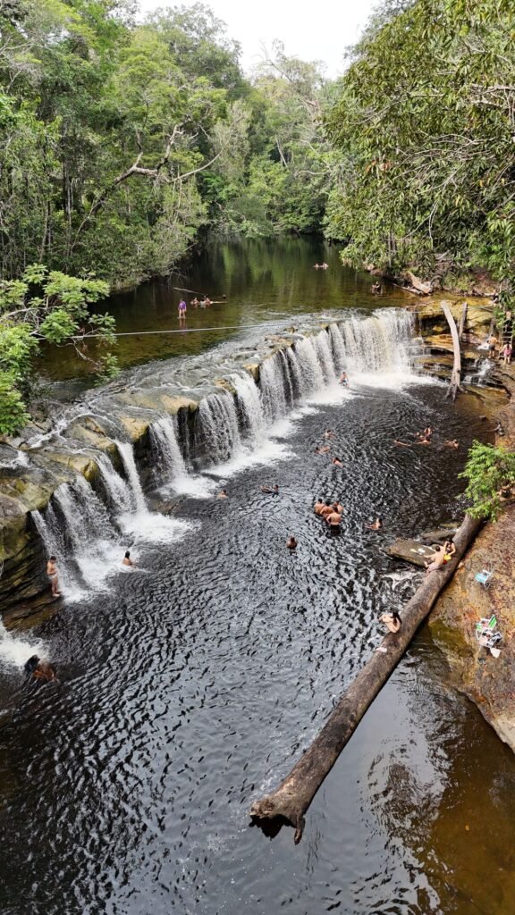 Pessoas nadando em poco de cachoeira na floresta