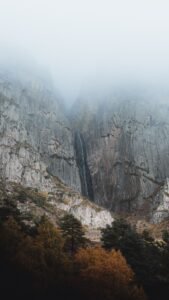 Paredões de cânion na névoa com cachoeira escondida
