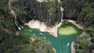 Paredões com cachoeiras e lago verde em Capitólio