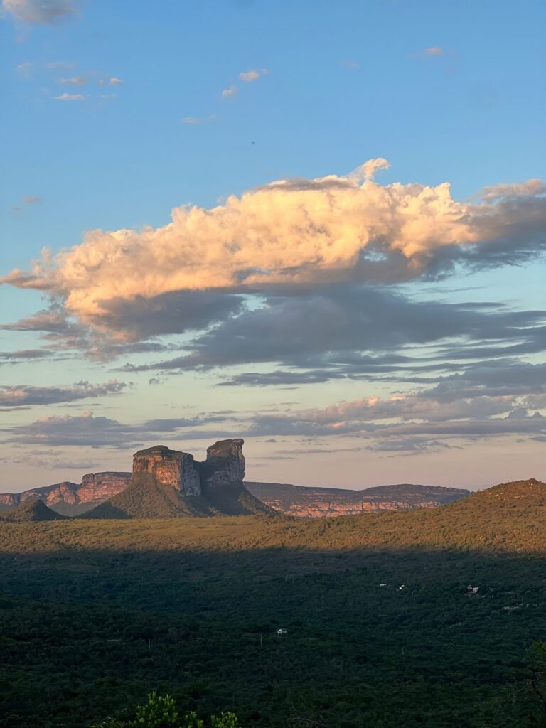 Pôr do sol com nuvens dramáticas sobre terreno verde de chapada