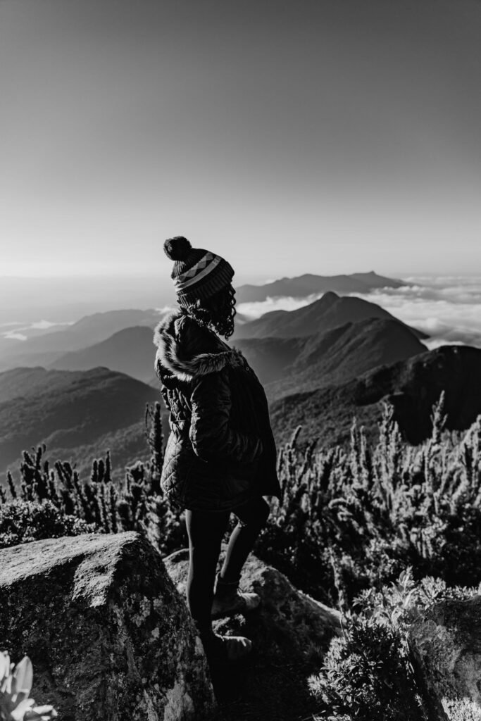 Mulher agasalhada em pico de montanha no Brasil