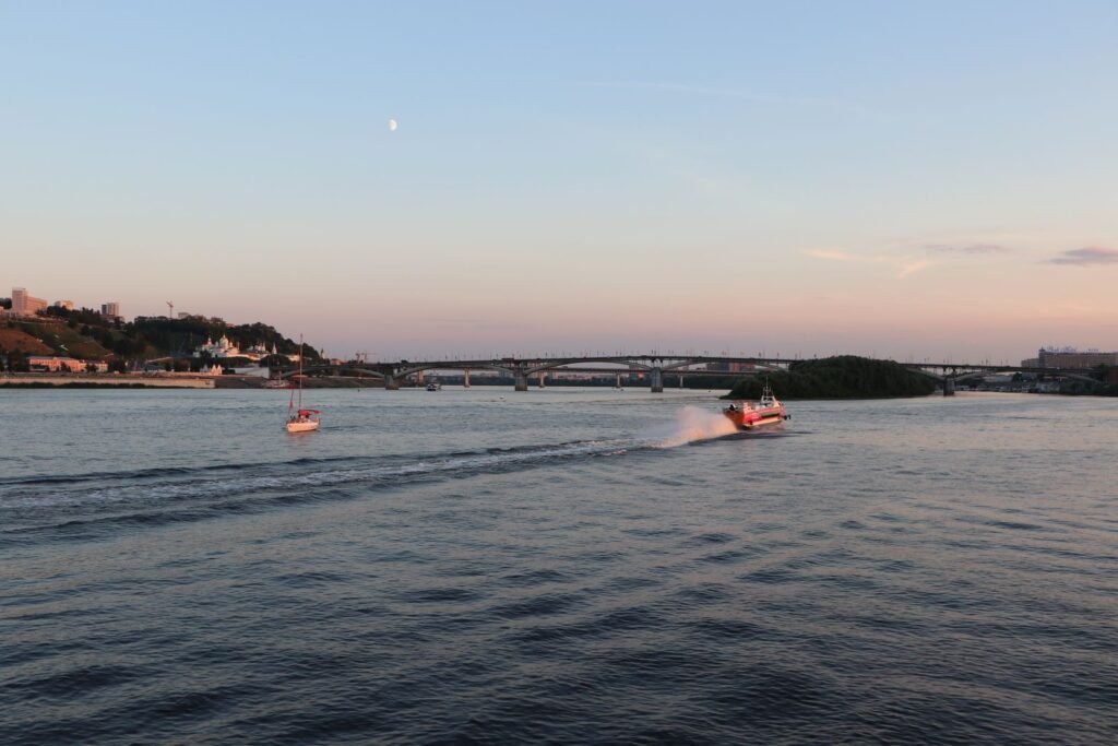 Barcos navegando em águas calmas ao pôr do sol