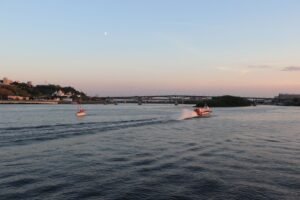 Barcos navegando em águas calmas ao pôr do sol