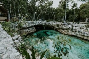 Poço natural profundo de águas cristalinas cercado por vegetação exuberante