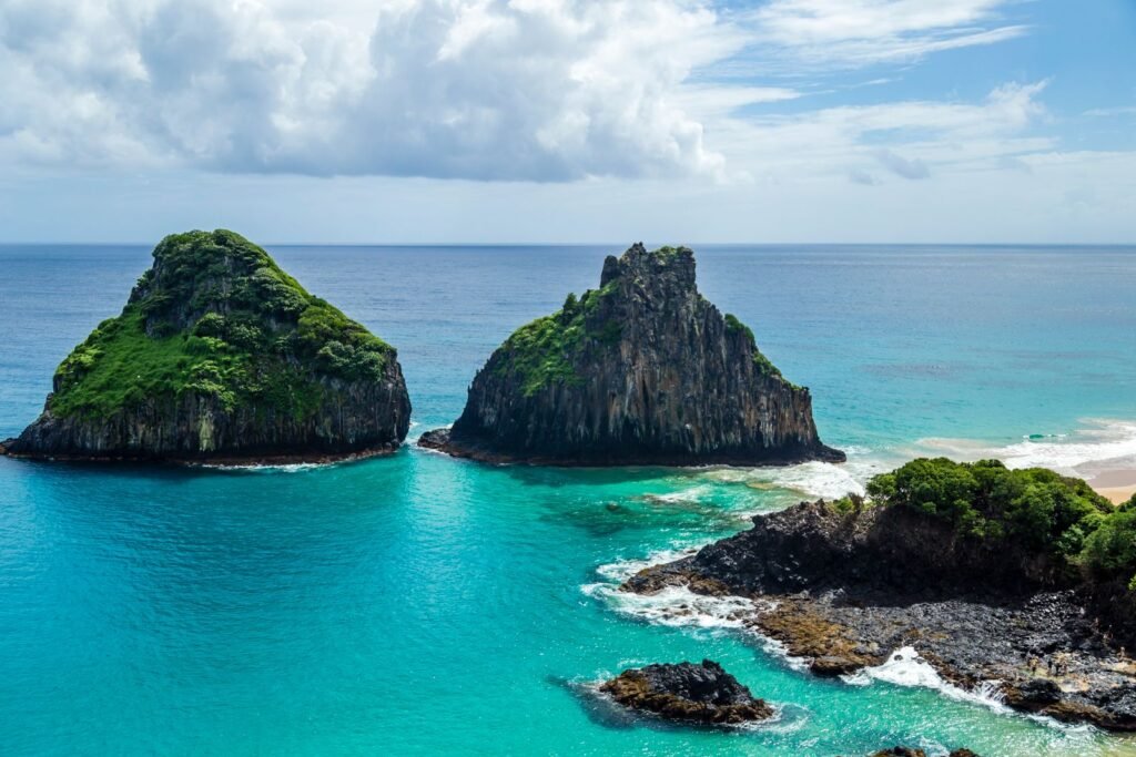 Morro Dois Irmãos emergindo do mar turquesa em Fernando de Noronha, Pernambuco