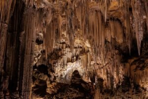 Estalactites e formações geológicas impressionantes em caverna iluminada