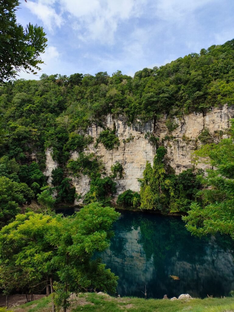 Lagoa de águas azuis profundas cercada por mata fechada