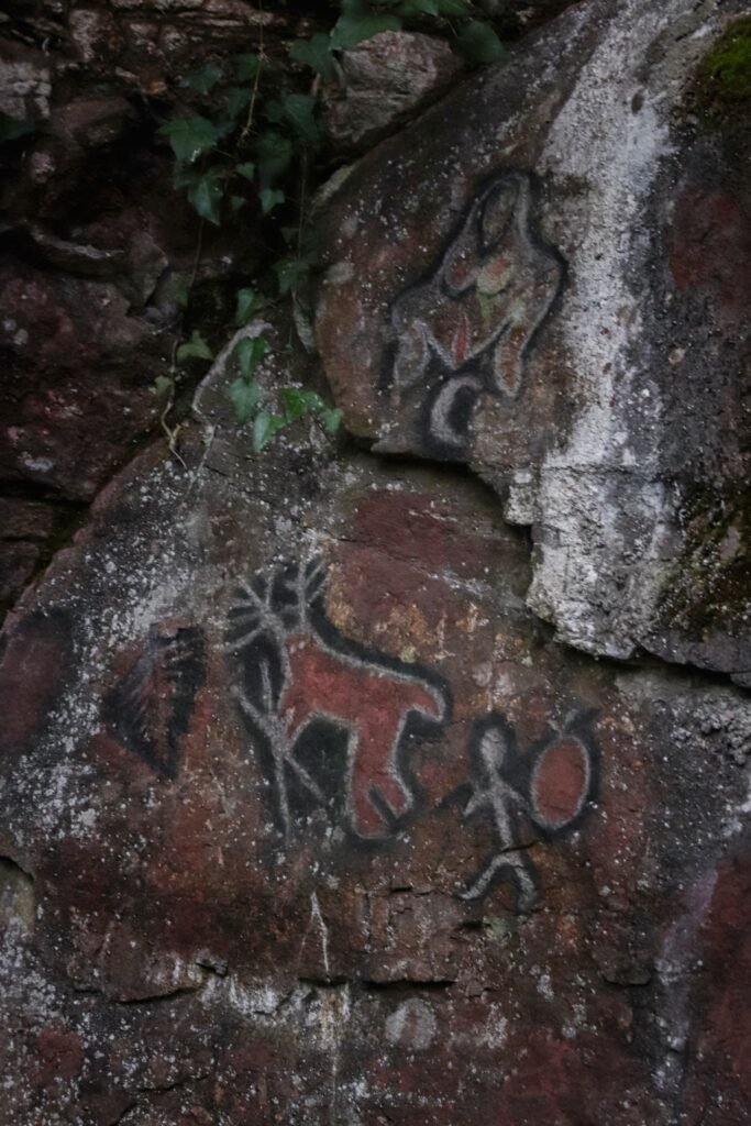 Pinturas rupestres antigas com símbolos e figuras em parede de pedra
