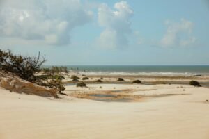 Praia deserta com areia e poças na maré baixa