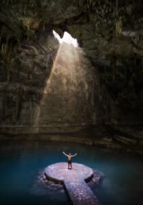 Feixe de sol iluminando águas azuis profundas de poço natural