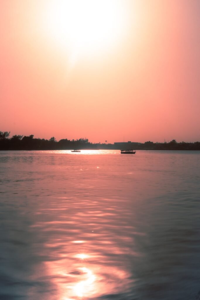 Barco navegando em rio tropical calmo ao pôr do sol