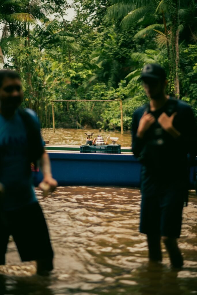 Pessoas e canoa em rio cercado de floresta