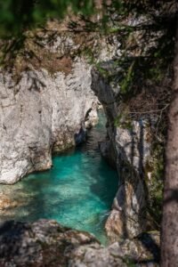 Rio de águas turquesa correndo entre cânion rochoso e vegetação