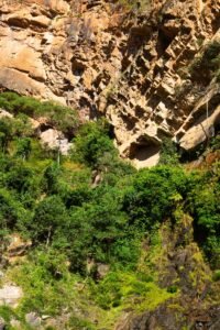 Formações de rocha avermelhada com vegetação verde, paisagem típica das serras do Brasil Central