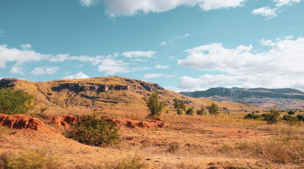Paisagem de campos abertos com serras ao fundo