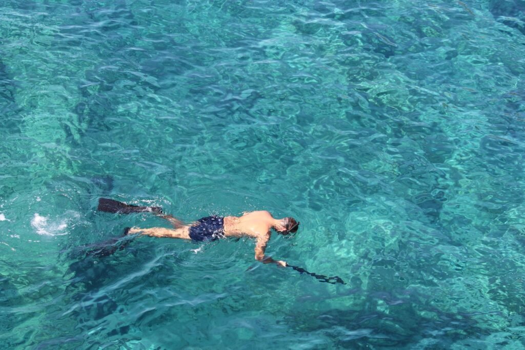 Mergulhador de snorkel em água turquesa