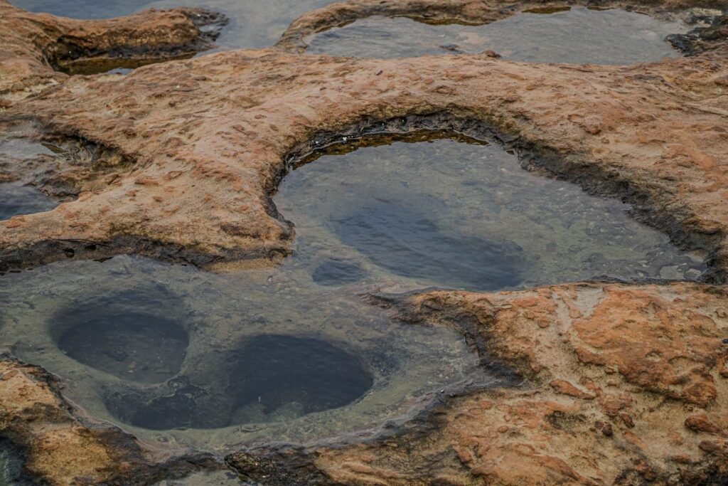 Formações rochosas com piscinas naturais rasas na maré baixa