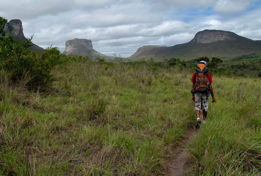 Trilheiro caminhando por paisagem selvagem na Chapada Diamantina