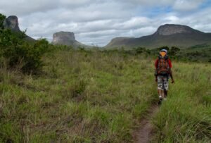 Trilheiro caminhando por paisagem selvagem na Chapada Diamantina