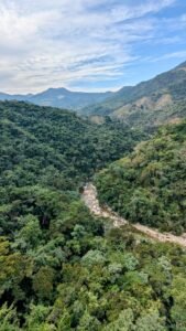 Montanhas verdes com rio serpenteando no vale